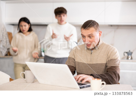 Couple quarreling with adult man with laptop 133878563