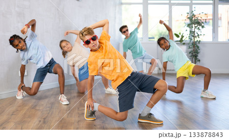 Preteenage boy and girl in sunglasses dancer practicing active dance in modern studio 133878843