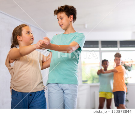Active preteen children practicing Ballroom dances in pairs in training hall Active preteen children practicing Ballroom dances in pairs in training hall 133878844