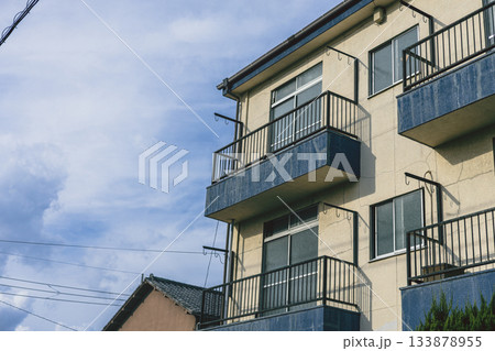 住宅街のレトロな外観のアパートと青空 133878955