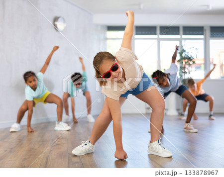 Girl in sun glasses perform choreographic exercise and teach social dance Jazz-modern with friends Girl in sun glasses perform choreographic exercise and teach social dance Jazz-modern with friends 133878967