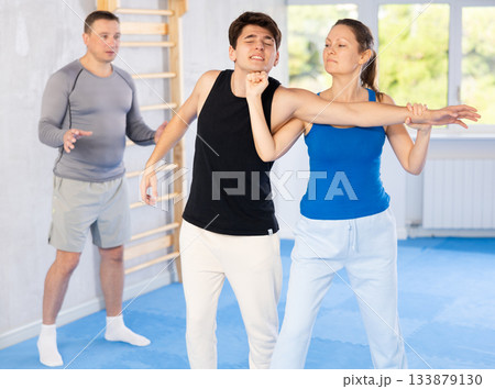 Guy paired up with woman to perform effective impact on pain points while learning self-defense. Guy paired up with woman to perform effective impact on pain points while learning self-defense. 133879130
