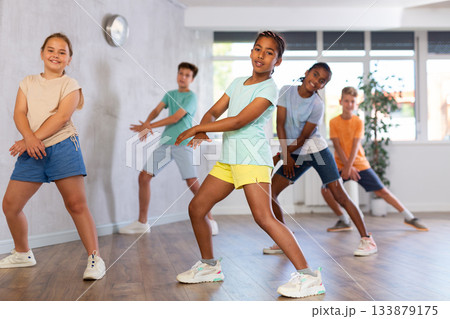 African girl perform choreographic exercises and teach energetic social dance waacking with friends African girl perform choreographic exercises and teach energetic social dance waacking with friends 133879175