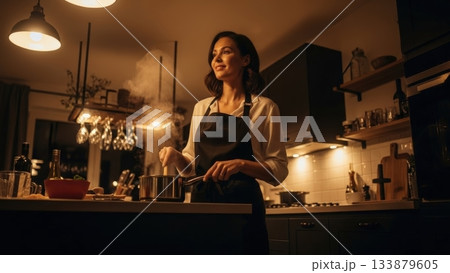 夕方の暖色ライトに照らされて料理をする女性のローアングルシーン 133879605