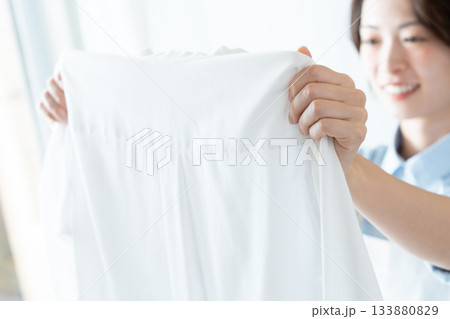 洗濯物を干す若い女性 133880829