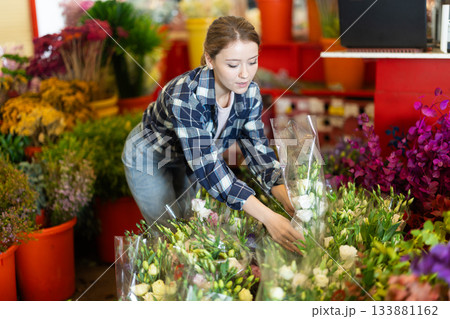 Female customer chooses a bouquet of roses in flower shop Female customer chooses a bouquet of roses in flower shop 133881162