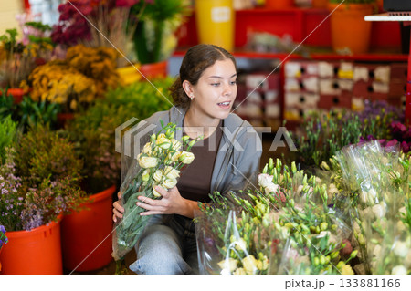 Girl salesman takes out bunch of eustoma from showcase, creates bouquets Girl salesman takes out bunch of eustoma from showcase, creates bouquets 133881166