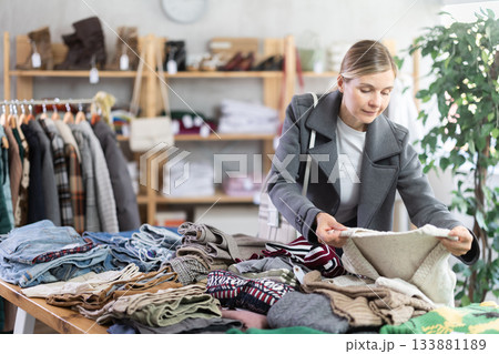 European woman browsing goods items and choose elect jumper for autumn 133881189