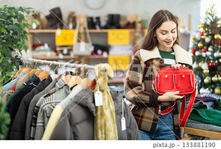 Woman client looks at products in store, choose closely ladys bag Woman client looks at products in store, choose closely ladys bag 133881190