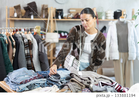 Adult woman choosing jeans in clothing store Adult woman choosing jeans in clothing store 133881194