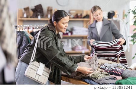 Asian woman browsing goods items and choose elect trousers Asian woman browsing goods items and choose elect trousers 133881241