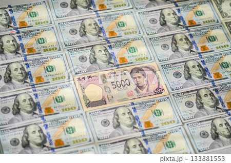 日本円5000円札を中心に配置した米100ドル紙幣の斜めショット・ぼかし気味 日本円5000円札を中心に配置した米100ドル紙幣の斜めショット・ぼかし気味 133881553