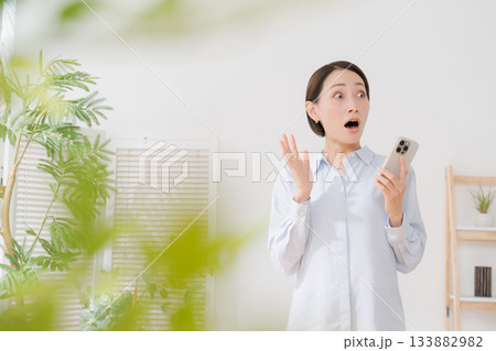 スマホを見て驚く表情の女性 スマホを見て驚く表情の女性 133882982