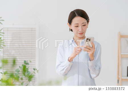 スマホを持つ40代女性 133883372
