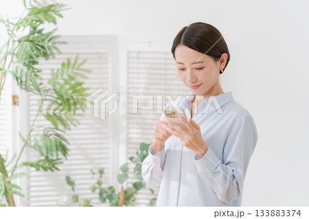 スマホを持つ40代女性 133883374