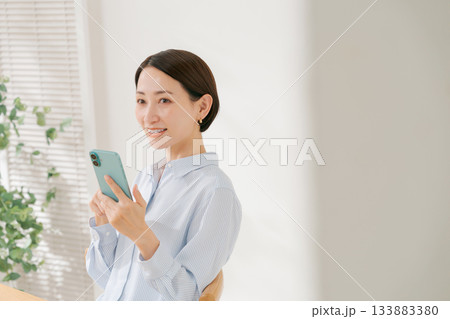 スマホを持つ40代女性 133883380
