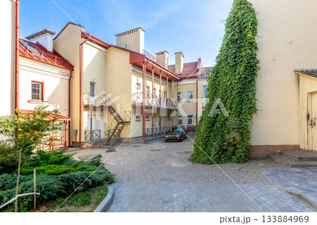 Sunny Courtyard with Residential Buildings, Ivy Wall and Parking Area Sunny Courtyard with Residential Buildings, Ivy Wall and Parking Area 133884969