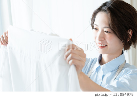 洗濯物を干す若い女性 133884979