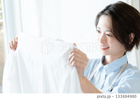 洗濯物を干す若い女性 133884980