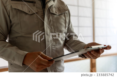 作業服の男性技術者が古民家で書類（見積書） 133885742