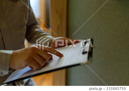 クリップボードで書類を確認し指差す作業員または技術者 133885750