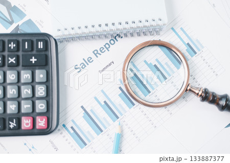 Magnifying glass with calculator and pen on financial reports with charts, graphs at office desk. Concept of business analysis, accounting audit, financial accuracy, transparency, corporate strategy. 133887377