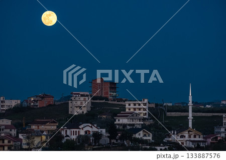 Full moon shines at night over small town in Balkans. Full moon shines at night over small town in Balkans. 133887576