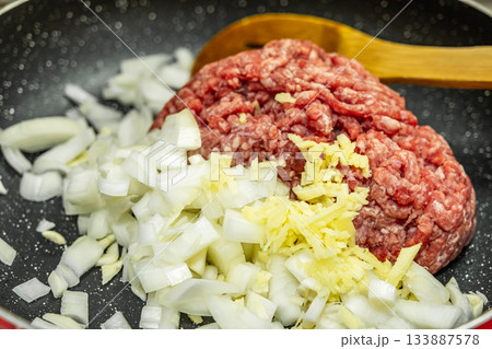 Minced meat with fresh onion on frying pan, Close up raw ground beef meat 133887578