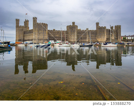 曇り空の下、水鏡となった満潮時の世界遺産カーナーヴォン城 (イギリス、ウェールズ、カーナーヴォン) 133888270