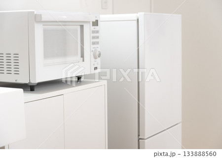 綺麗な白い冷蔵庫と電子レンジのあるミニキッチン 133888560
