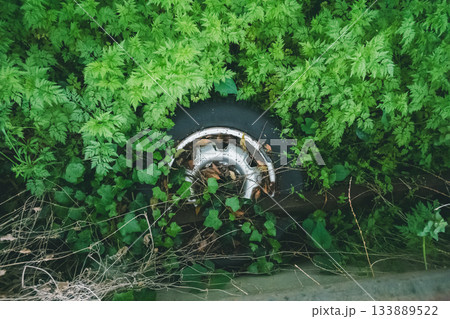 草むらに不法投棄された古タイヤ 133889522