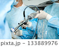 The surgeon operates with laparoscopic manipulators. 133889976