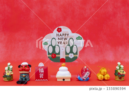 赤い背景とミニチュアの正月飾り、門松、鏡餅、獅子舞、新年を祝う縁起物素材 赤い背景とミニチュアの正月飾り、門松、鏡餅、獅子舞、新年を祝う縁起物素材 133890394