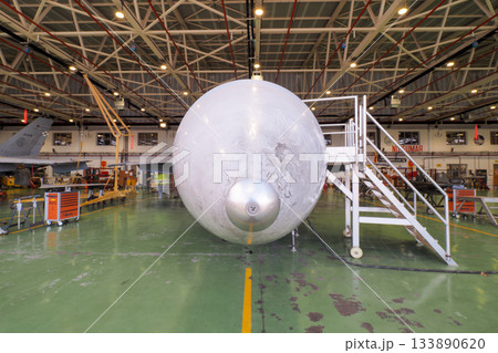 Front view of fighter jet radome and nose gear in hangar 133890620