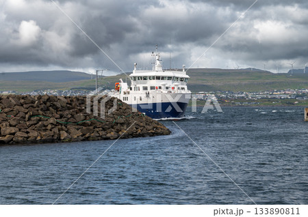 Passenger ferry arriving at Nolsoy, Faroe Islands, with scenic coastal landscape, colorful houses, and calm North Atlantic waters. Passenger ferry arriving at Nolsoy, Faroe Islands, with scenic coastal landscape, colorful houses, and calm North Atlantic waters. 133890811