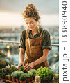 Woman gardening herbs on urban balcony at sunset 133890940