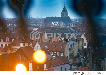 Festive Bruges square illuminated with Christmas lights and decorations, showcasing holiday market stalls and charming historic architecture. 133891076
