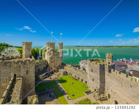 メナイ海峡を背景に見る世界遺産カーナーヴォン城のイーグルタワーと外郭の全景 (イギリス、ウェールズ) 133891292