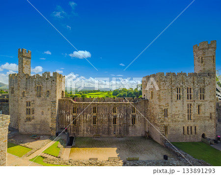 青空の下のカーナーヴォン城、大広間跡と二つの塔 (イギリス、ウェールズ、カーナーヴォン) 133891293