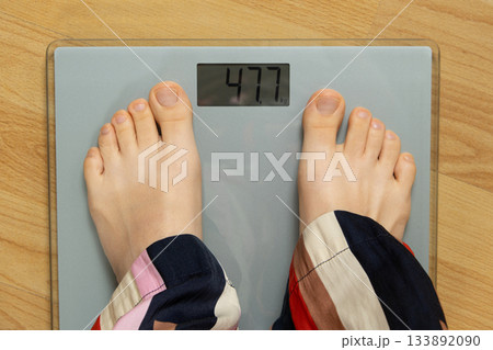 Top View of Bare Feet Standing on Modern Digital Bathroom Scales for Weighing. 133892090