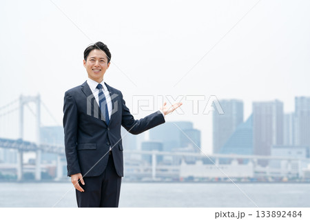 ビジネスマン　空　都会　手かざし 133892484