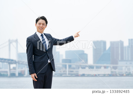 ビジネスマン　空　都会　指差し 133892485