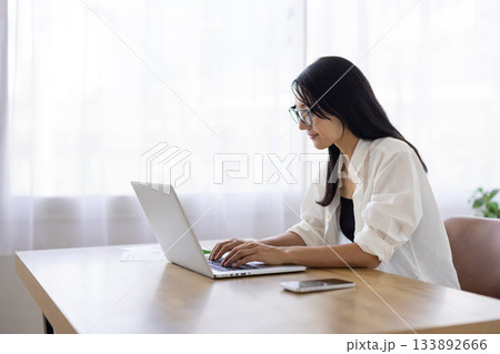 パソコンで作業をするメガネをかけた女性 パソコンで作業をするメガネをかけた女性 133892666
