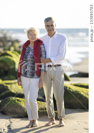 Happy senior couple enjoying beach vacation together Happy senior couple enjoying beach vacation together 133893783