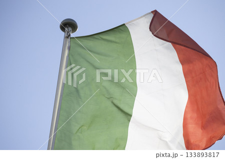 Italian flag waving against blue sky representing national identity 133893817