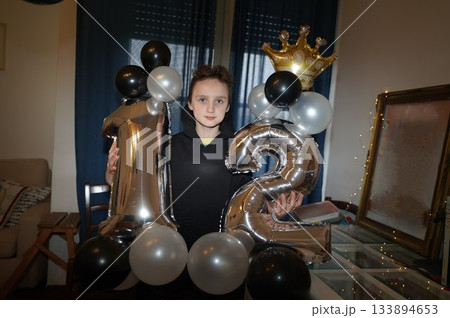 Child Celebrating Twelfth Birthday with Balloon Display Child Celebrating Twelfth Birthday with Balloon Display 133894653
