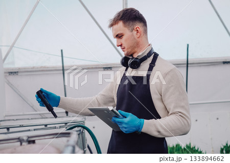 Physiologist analyzing tulip growth conditions carefully, Agricultural scientist conducting detailed experiments on tulips using specialized equipment and careful measurements 133894662