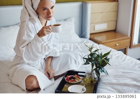 Happy Girl with a Cup of Coffee. Home Style Relaxation Woman Wearing Bathrobe and Towel after Shower. Spa Good Morning 133895061