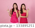 Party Celebration. Two women enjoying a festive moment with drinks and smiles. 133895251