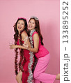 Party Fun. Two cheerful women posing together with drinks and festive decorations. 133895252